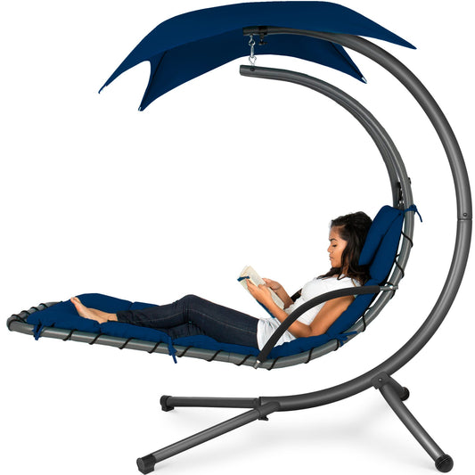 Hanging curved steel chaise lounge swing with canopy and pillow, navy blue.