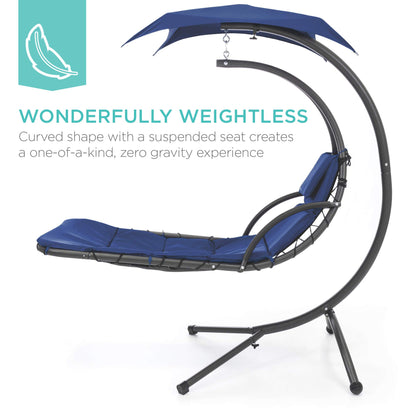 Hanging curved steel chaise lounge swing with canopy and pillow, navy blue.